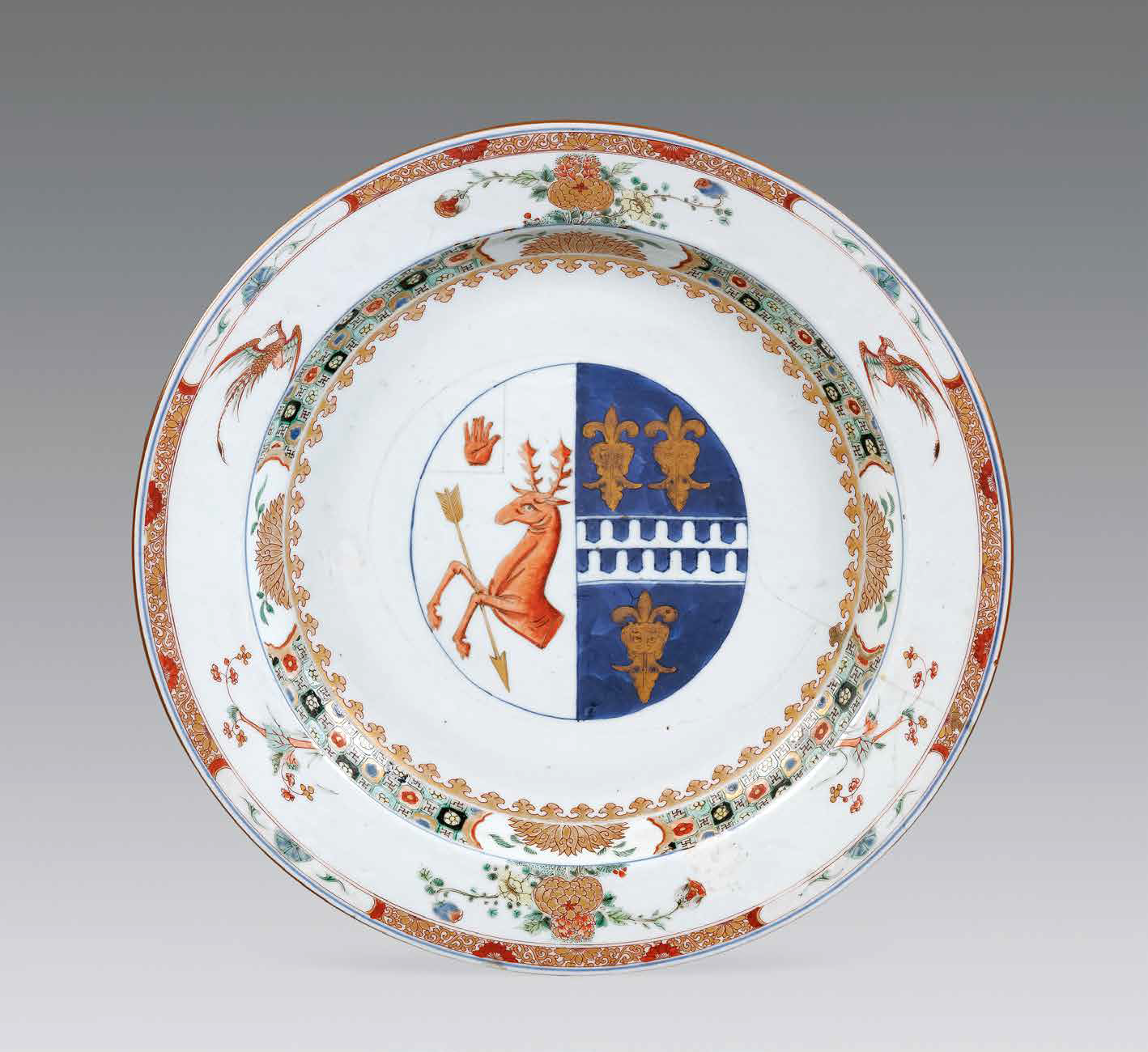 “外銷瓷”是指我國生產(chǎn)的，專門銷往國外的瓷器，清代“一口通商”時期，中國瓷器遠銷歐美，對歐美人民生活影響深遠。這一時期輸出的瓷器種類眾多，有粉彩、廣彩、青花、五彩等，器物造型及紋飾圖案既保留了中國制瓷藝術的傳統(tǒng)特征，又汲取了歐美的藝術精華，從而燒制出了大量精美的瓷器。圖為清康熙Decker家族和Watkins家族聯(lián)姻紋章大盤。外銷瓷中常見兩個家族組合紋章的紋章瓷，這樣的瓷器通常是為家族成員聯(lián)姻而定